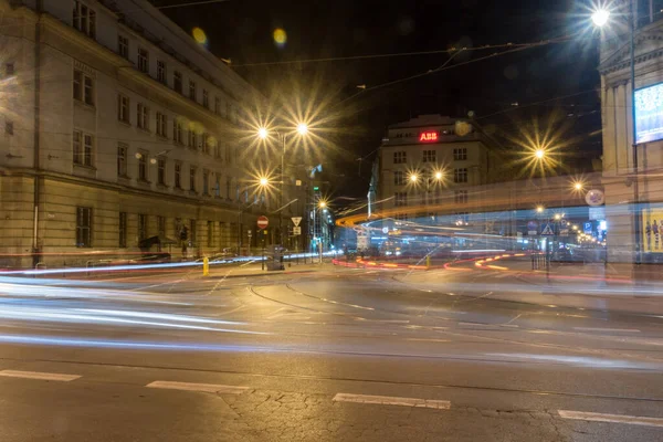 Krakow 'un merkezindeki cadde kavşağında gece araba ışığı izleri var..