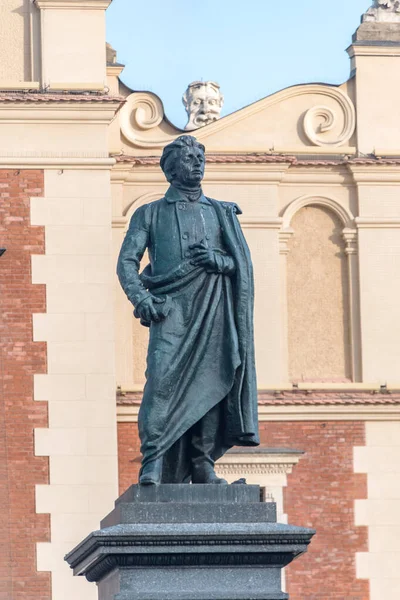 Primer plano del monumento Adam Mickiewicz con la sala de telas en el fondo en Cracovia, Polonia . — Foto de Stock