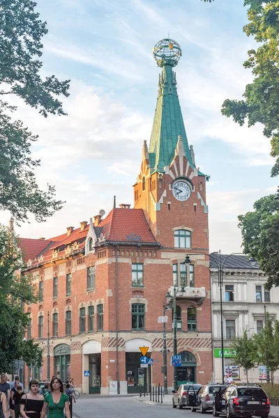 Un edificio con una torre de reloj en la esquina de las calles dluga y basztowa en el casco antiguo de Cracovia . — Foto de Stock
