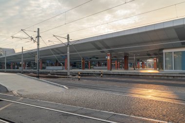 Güneş doğarken Krakow Parlak Tren İstasyonu 'ndaki platformlar.