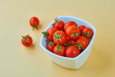 Sarı zemin üzerine beyaz kase kiraz domates