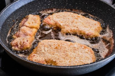 Şnitzel domuz sıcak tava üzerinde hazırlanıyor