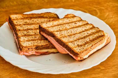 Beyaz tabakta jambon ve peynir ile tost