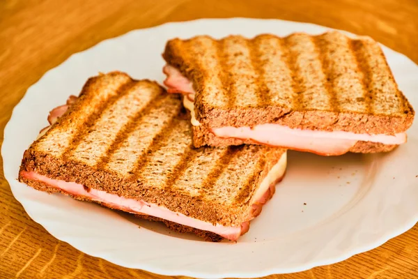 Beyaz tabakta jambon ve peynir ile tost
