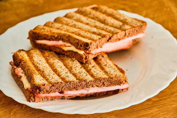 Beyaz tabakta jambon ve peynir ile tost