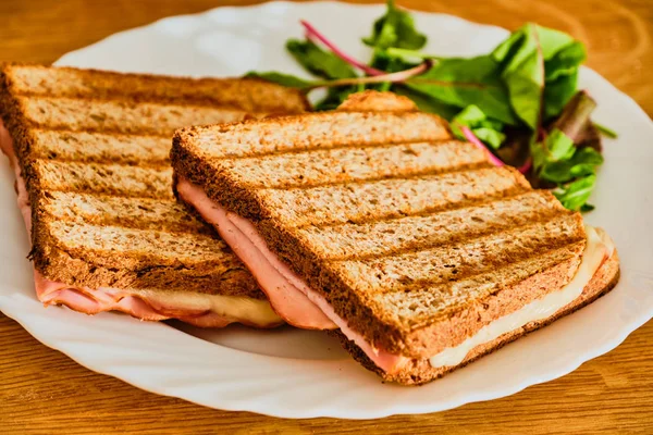 Beyaz tabakta jambon ve peynir ile tost