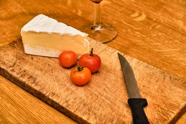 Kesme tahtasında mavi peynir ve bıçak ve kırmızı şarap.