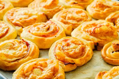 Fırın tepsisinde jambon ve peynirli taze puf börekleri.