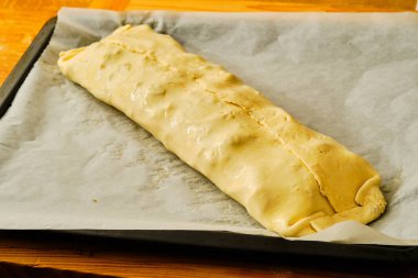 Pasta hamurundan ev yapımı elmalı turta hazırlıyorum. Pasta kağıdına yumurta sürülmüş.