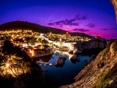 Dubrovnik Hırvatistan Adriyatik Denizi üzerinde tarihi eski kasaba ve şehir duvarları üzerinden bakan muhteşem pembe ve mor renkli erken sabah görüntülemek.