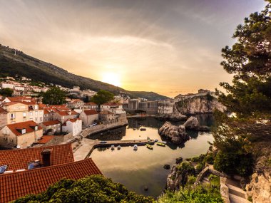 Gündoğumu ile Adriyatik Denizi ön planda uzakta sessiz bir küçük koy, tarihi eski kasaba ve şehir duvarları Dubrovnik Hırvatistan üzerinde bakan muhteşem görünümü.