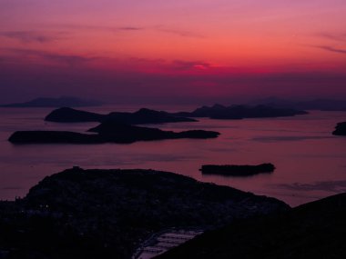 Muhteşem renkli pembe ve mor günbatımı ve Adaları içinde kapalı bir güzel arka plan resmi ya da kır manzarası yapma sahil Dubrovnik Hırvatistan Adriyatik Denizi'nin sularına bakan yansımalar.