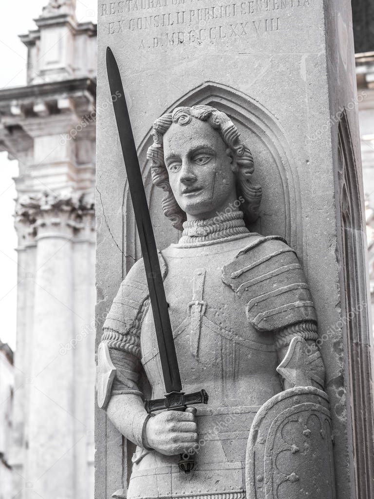 Close up photograph of the sword yielding knight carved in the historic Orlando Column in Luza Square in Dubrovnik Croatia.