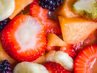 Çilek, kavun, böğürtlen, armut, muz ve portakal suyu da dahil olmak üzere bir mouthwatering meyve salatası resmi kapatın.