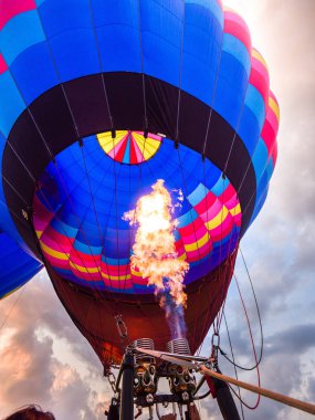 Fotoğraf bir sıcak hava balonu içinde seyir yakından bir ateş topu ya da alevler yukarı doğru dramatik bulutlar ile renkli balon içine gün batımında çekim ötesinde Galena Illinois.