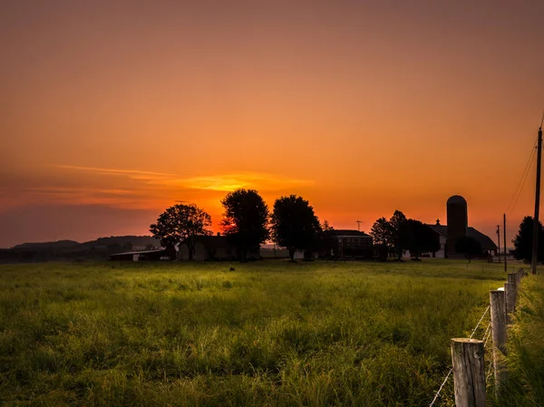 Wunderschöner Orangefarbener Und Gelber Sonnenaufgang Mit Einem Bauernhof Silhouette Horizont — Stockfoto