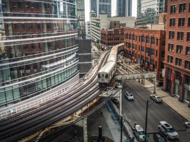 Chicago, IL - 6 Haziran 2018: Kahverengi çizgi Cta tren insanlar işten eve dönüş yolunu yaparken parça Kimball doğru uzak şehir başlık bir s-curve kısmını kendine yol yapar.