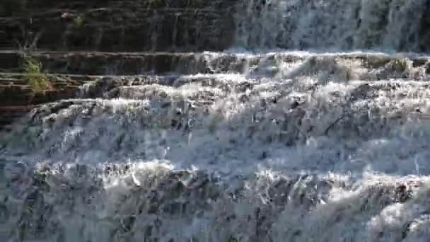 Close up real-time view panning down the rocky stepped cliff of the beautiful Thunder Bay Waterfall as water splashes down the limestone surface into the pool below in Galena Illinois. — Stock Footage Close Real Time View Panning Rocky Stepped Cliff Beautiful Thunder Stock Footage