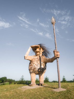 Lisle, IL - July 7th, 2018: Joe the guardian a giant troll sculpture created from reclaimed lumber by Thomas Dambo watches over the nearby highway and visitors of the Morton Arboretum on a sunny day. clipart