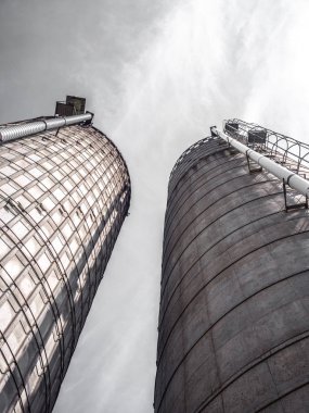 Uzun boylu hububat silosuna diğer tarafa aşağıdan bir gri bulutlu gökyüzü yukarıdaki ile seyir dramatik endüstriyel veya tarım fotoğraf.
