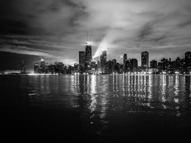 Güzel Chicago gece manzarası fotoğraf dramatik bulutlar yukarıdaki ve Michigan Gölü su üzerinde yansıtan bina ışıkları.