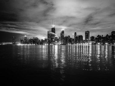 Güzel Chicago gece manzarası fotoğraf dramatik bulutlar yukarıdaki ve Michigan Gölü su üzerinde yansıtan bina ışıkları.