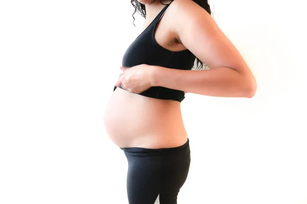 彼女の大きな腹やタイトなパンツやレギンスを身に着けている胃を公開する彼女の黒のタンクトップを持ち上げ腰に首から妊娠中フィットのアフリカ系アメリカ人女性の側の肖像 — ストック写真