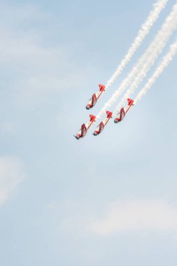 Chicago, IL - August 20th, 2017: The Aeroshell aerobatic team descends in formation leaving a trail of smoke over the city entertaining the crowds watching from below at the annual Air and Water show. clipart