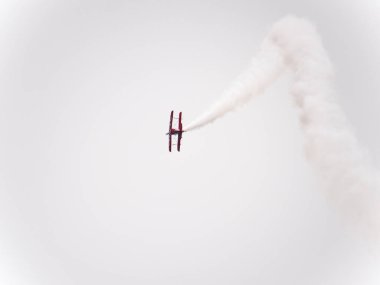 Chicago, IL - August 18th, 2018: Legendary Sean Tucker performs aerobatic stunts leaving trails of smoke over the city and entertaining the crowds watching from below at the annual Air and Water show. clipart