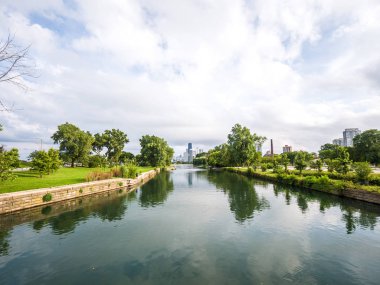 Chicago, Il - 29th Ağustos 2018: A adam balıklar yükü tarafından kümülüs bulutlar rulo olarak Lincoln Park kürek kanal geçer ve kıyı.