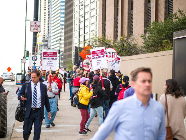 Chicago, IL - September 27th 2018: Hotel workers on strike picket in front of Hyatt Chicago marching with signs and hitting drums while chanting in protest as they fight for better benefits and wages.