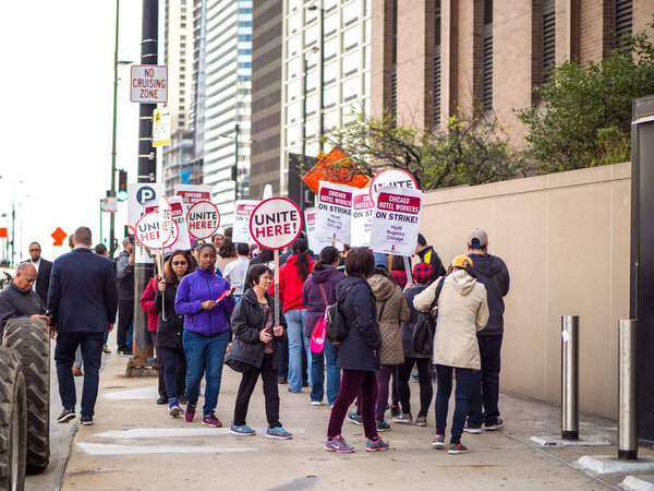 Chicago, IL - September 27th 2018: Hotel workers on strike picket in front of Hyatt Chicago marching with signs and hitting drums while chanting in protest as they fight for better benefits and wages.