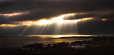 Güzel dramatik sarı güneş ışınları Parlatıcı cumulus bulutları Michigan Gölü su ve kıyı bir fantastik doğa panorama arka plan yapma Chicago kışın beslemek beach civarındaki bir boşlukta aracılığıyla.