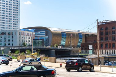 Milwaukee, Wisconsin - May 26th, 2018: The new Milwaukee Bucks Fiserv Forum multi-purpose basketball arena's curved roof rises above nearby buildings adjacent to the Milwaukee River in downtown. clipart