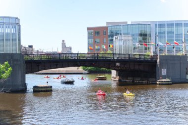 Milwaukee, Wisconsin - 26 Mayıs 2018: onlar Milwaukee nehir su üzerinde kırmızı ve sarı kayaks köprü altında kürek şehir merkezinde bir sıcak bahar sabahı gibi insanlar bir gün eğlence zevk.
