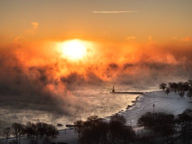 Gün doğumu sırasında kış 2019 sıfırın altında ile kutup girdap Michigan Gölü yükselen buhar üzerinde güzel bir hava fotoğrafı sıcaklıklarda kar kaplı Foster Beach.