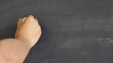 Bir kadın eli tozlu kullanılan yazı tahtası veya sarı tebeşir büyük bir parçası ile kara tahta üzerinde kelime Merhaba bir ünlem işaretiyle yazma bir closeup.