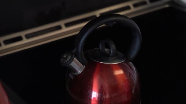 ハンドル黒とクローム噴出蒸気を吹きし どうこくホイッスル ノイズを示すその熱いストーブの上使用される光沢のある赤いやかんの — ストック動画