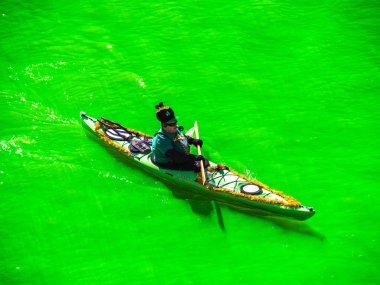 Chicago, IL-16 Mart, 2019: Insanlar şenlikli St. Patrick 's gün giysiler içinde yeşil nehir aşağı kayaklar kürek giymiş yıllık boyama ve kutlama şehir merkezinde sonra yakın bir göz almak için.