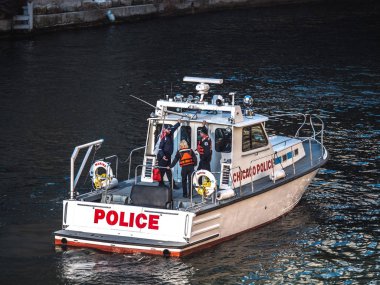 Chicago, IL-16 Mart, 2019: Chicago polis tekneleri şehir merkezindeki kıyı boyunca kalabalıklar olarak nehir boyama yıllık St Patrick gün önce nehir temizlemek için onların mermi yapmak.