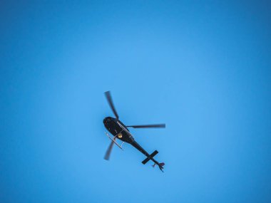 Bir helikopter veya helikopter parlak mavi gökyüzü arka planda havai gezinen.
