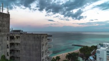 Montego Bay, Jamaika - 24 Mart 2019: Turistler uyanmaya başlarken sessiz ve sakin bir sabahta gün doğumunda S Hotel ve Doctor's Cave Beach'in üzerinden bulutlar geçiyor.
