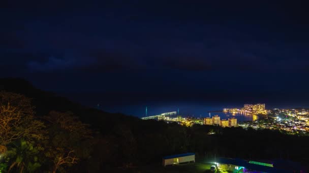 A panning timelapse overlooking the bay in Ocho Rios at night with lights on buildings and flashing at nearby bars, clubs and nightlife on the tropical island of Jamaica as darkness comes. — Stock Video