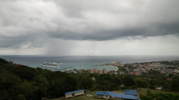 Ocho Rios, Jamaica-28 mars 2019: Island Princess kryssningsfartyg och dess passagerare avgår hamn i Atlanten som stormiga väder och regnmoln flytta in i viken nedan. — Stockvideo