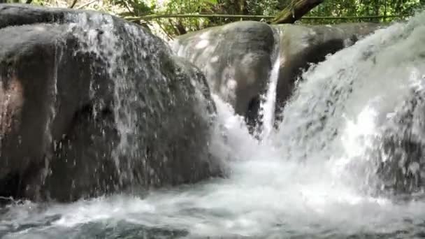 Медленное движение крупным планом водопада по прозвищу стиральная машина, поскольку белые пороги воды льются через округлые известняковые породы в реке Мэйфилд Фоллс на тропическом острове Ямайка . — стоковое видео