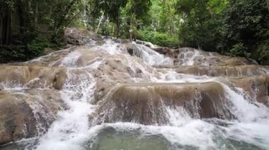 Dunn'ın nehrinde kayalar üzerinde basamaklı su bakan güzel bir görünüm Jamaika popüler bir seyahat hedef tropik adada Ocho Rios arka planda yemyeşil bitki örtüsü ile düşüyor.