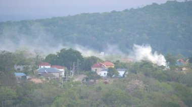 Ocho Rios, Jamaika - 30 Mart 2019: Beyaz duman bir yerleşim alanı yakınında bir yangın dan ağaçlar ve çatılar üzerinde yükselir ve huzurlu bir Cumartesi sabahı erken sürükleniyor.