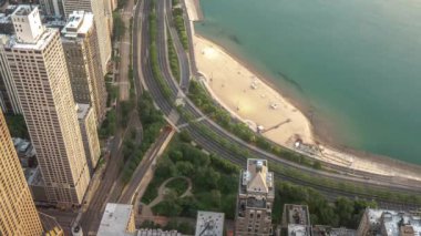 Chicago, Il - 13 Temmuz 2019: Birkaç kişi Michigan Gölü'nün berrak sakin sularında yakındaki Oak Street Beach dışarı girişim başlar gibi trafik yavaş yavaş Lake Shore Drive Cumartesi sabahı erken inşa