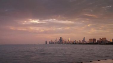 Chicago, Il - 4 Temmuz 2019: Kalabalıklar Montrose Limanı yakınlarındaki Michigan Gölü boyunca toplanarak 4 Temmuz'u kutladılar ve şehrin siluetinde güneşin battığını izliyorlar..