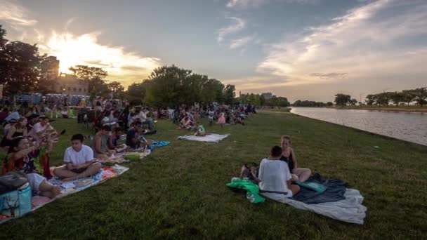Chicago, Il-20 juli 2019: folkmassor börjar samlas för Chicagos första Water Lantern Festival på South Lagoon i Lincoln Park på lördagen när solen börjar ställa under horisonten. — Stockvideo